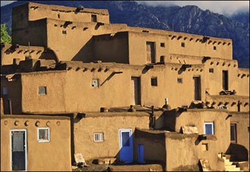 three-story pueblo with mountain in background